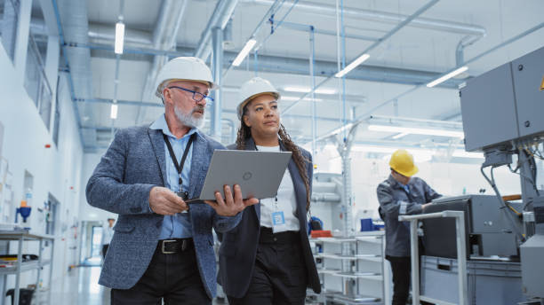 People wearing helmet and suits walking in a factory